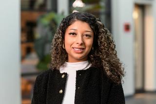 a woman with curly hair standing in front of a building